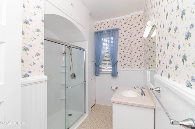 bathroom with ornamental molding, a shower with door, and vanity