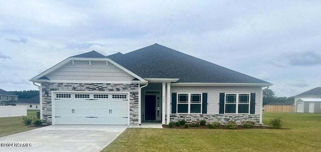 craftsman inspired home with a garage and a front lawn