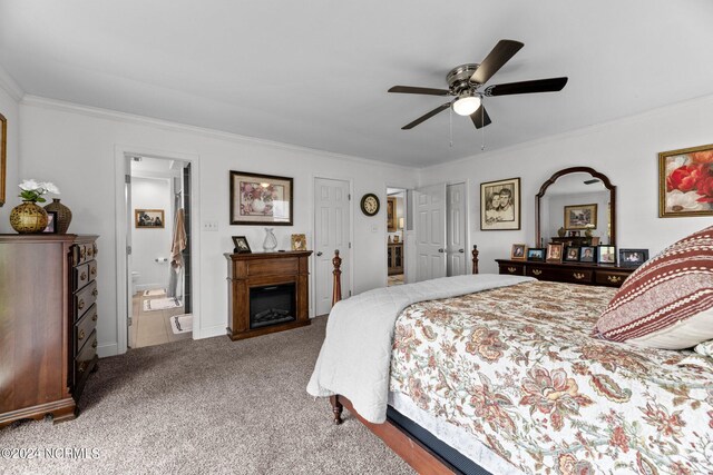 carpeted bedroom featuring ceiling fan, ensuite bath, and crown molding