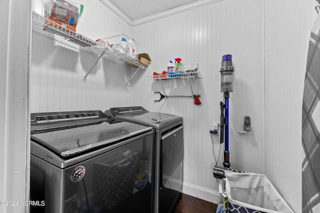 laundry area featuring washer and clothes dryer, ornamental molding, a textured ceiling, and dark hardwood / wood-style flooring