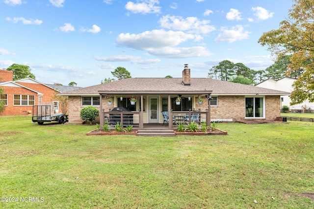 rear view of house with a yard and a deck