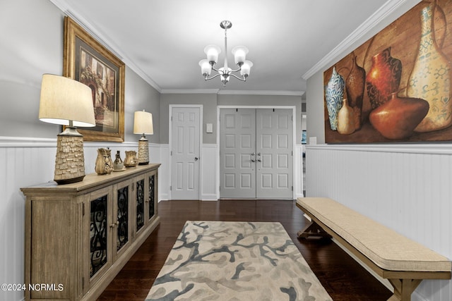 foyer featuring a chandelier, dark hardwood / wood-style floors, and crown molding