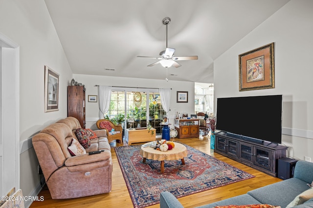 living room with ceiling fan, hardwood / wood-style flooring, and lofted ceiling