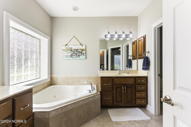 bathroom with tile patterned floors, vanity, and tiled tub