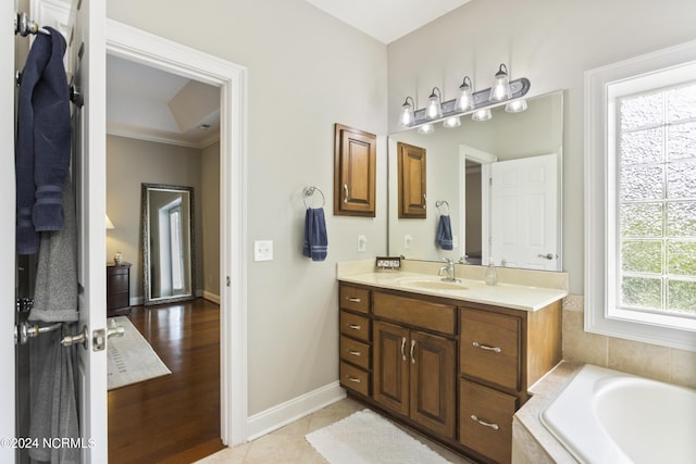 bathroom with tiled tub, vanity, and tile patterned floors