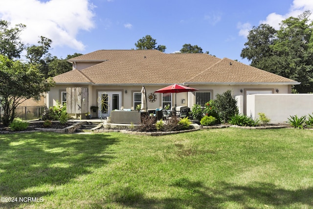 rear view of house with french doors, a yard, an outdoor living space, and a patio area