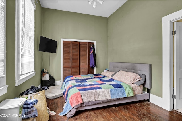 bedroom with dark hardwood / wood-style flooring and a closet