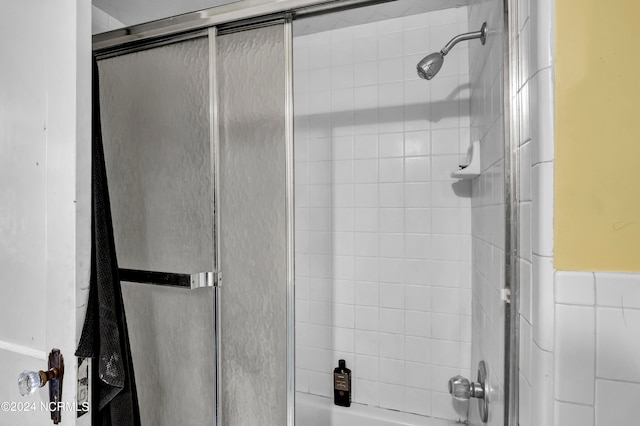 bathroom with shower / bath combination with glass door