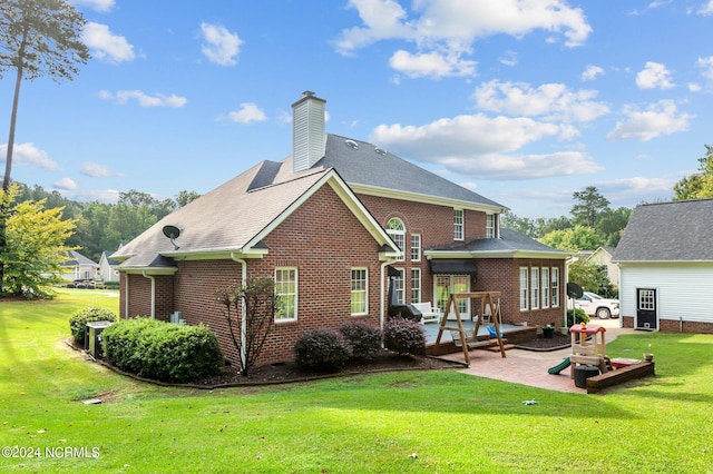 back of house with a lawn and a patio