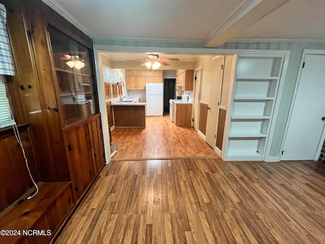 interior space featuring light wood-style flooring, white appliances, a sink, light countertops, and ornamental molding