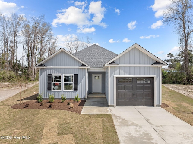 308 Camp Creek Dr, Oriental, NC 28571 - view of front of house with a garage, concrete driveway, a front lawn, board and batten siding, and roof with shingles