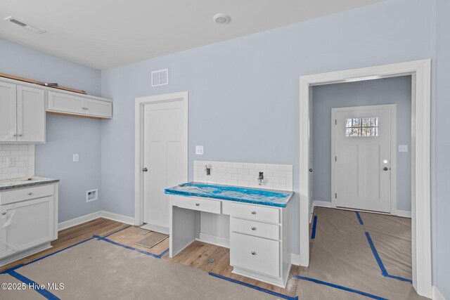 308 Camp Creek Dr, Oriental, NC 28571 - interior space with baseboards, white cabinets, visible vents, and backsplash