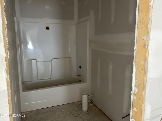 bathroom with shower / bathing tub combination and concrete floors