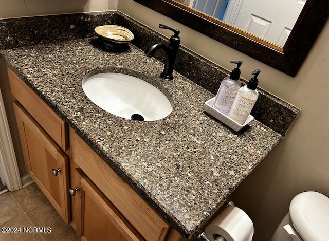 bathroom featuring vanity, tile patterned flooring, and toilet