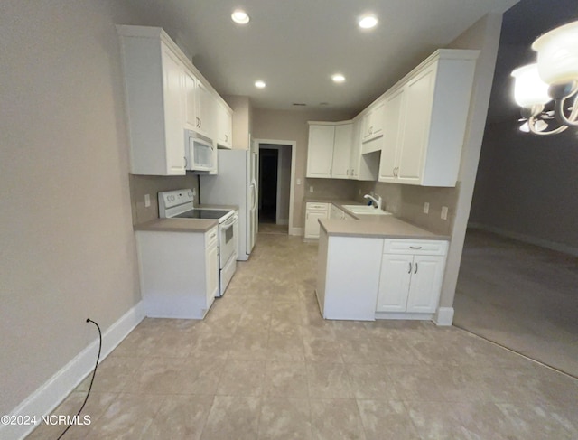 kitchen with white appliances, white cabinetry, and sink