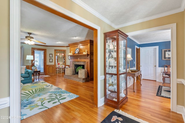 interior space with light hardwood / wood-style floors, crown molding, and a textured ceiling