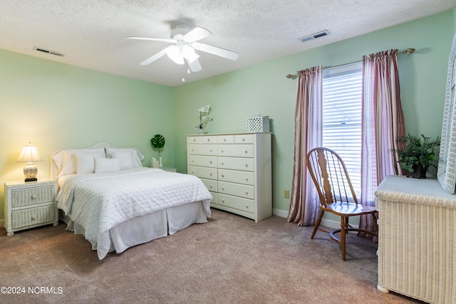 bedroom with a textured ceiling, carpet, and ceiling fan