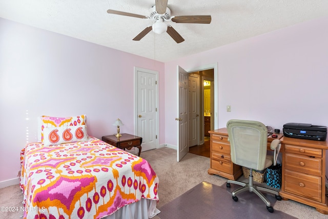 carpeted bedroom featuring ceiling fan and a textured ceiling