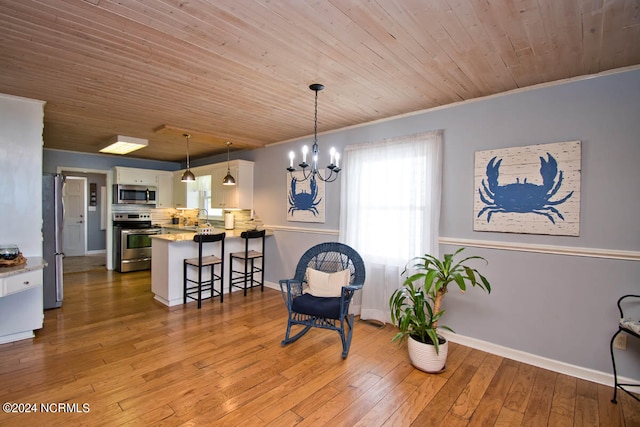 living area featuring crown molding, wood ceiling, hardwood / wood-style floors, and a notable chandelier