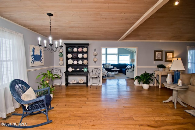 living area featuring a notable chandelier, wood-type flooring, wooden ceiling, and crown molding