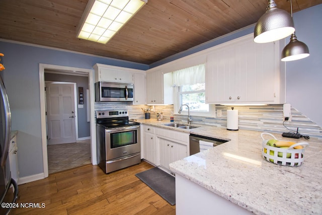 kitchen with pendant lighting, sink, white cabinetry, stainless steel appliances, and light hardwood / wood-style floors