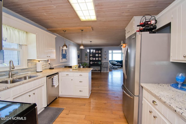 kitchen with pendant lighting, kitchen peninsula, white cabinetry, stainless steel appliances, and light hardwood / wood-style floors