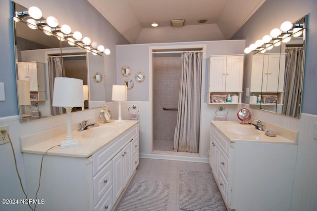 bathroom featuring lofted ceiling, vanity, curtained shower, and tile patterned flooring