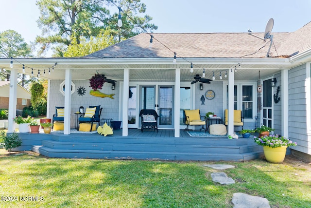 rear view of property featuring ceiling fan, a porch, and a lawn