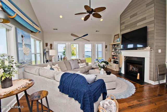 living room featuring ceiling fan, lofted ceiling, dark hardwood / wood-style flooring, and a healthy amount of sunlight