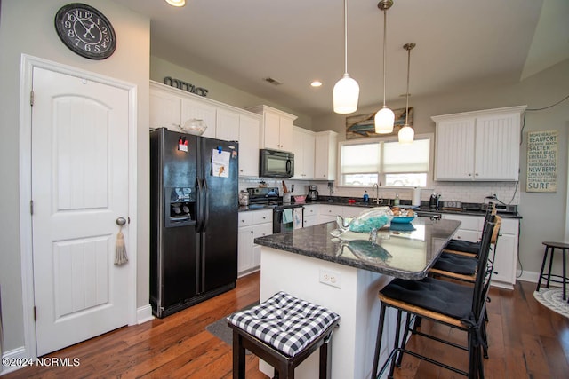 kitchen featuring white cabinets, a center island, dark hardwood / wood-style floors, and black appliances