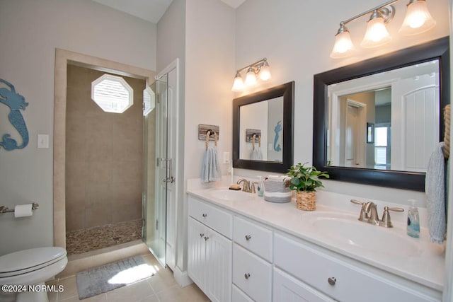 bathroom with vanity, a tile shower, toilet, and a healthy amount of sunlight