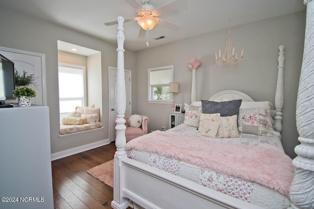 bedroom with ceiling fan with notable chandelier, dark hardwood / wood-style flooring, and multiple windows