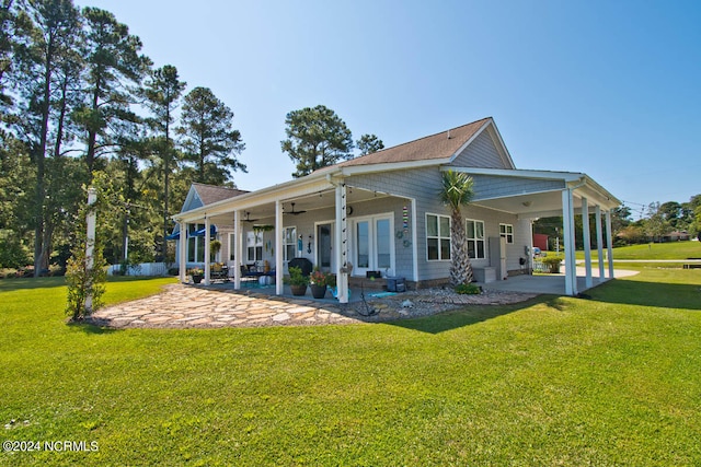 back of property with ceiling fan, a lawn, and a patio area