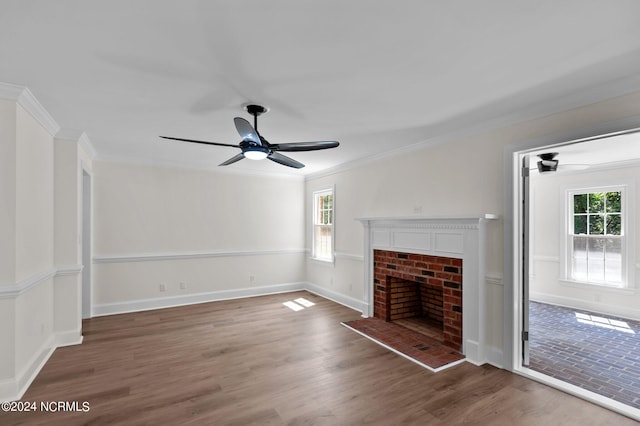 unfurnished living room featuring ceiling fan, a fireplace, dark hardwood / wood-style floors, and a healthy amount of sunlight