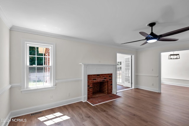 unfurnished living room featuring ceiling fan, a fireplace, crown molding, and dark hardwood / wood-style flooring