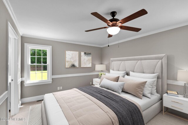 carpeted bedroom with ornamental molding and ceiling fan