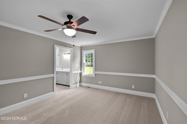 empty room featuring ceiling fan, crown molding, and light carpet