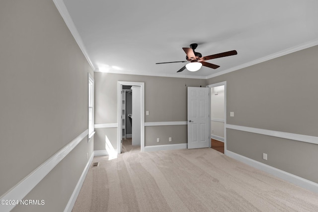 unfurnished room featuring ceiling fan, crown molding, and light carpet