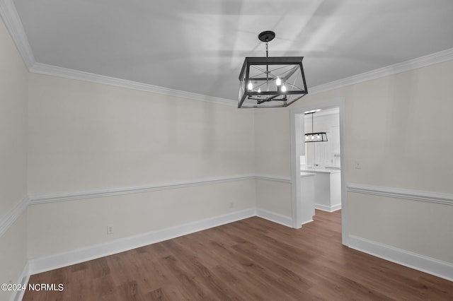 unfurnished dining area with ornamental molding, dark wood-type flooring, and a chandelier