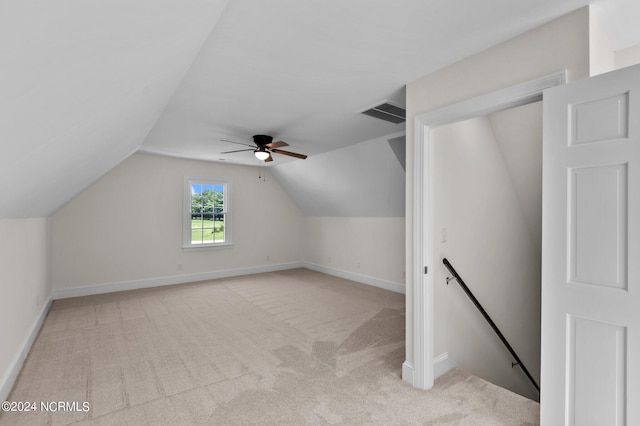 additional living space featuring vaulted ceiling, light carpet, and ceiling fan