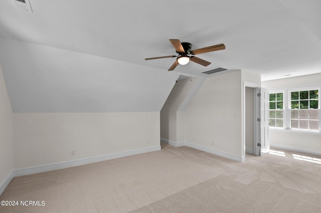 bonus room with vaulted ceiling, ceiling fan, and light colored carpet