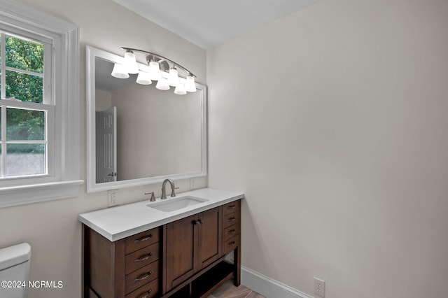 bathroom with hardwood / wood-style floors, vanity, and toilet