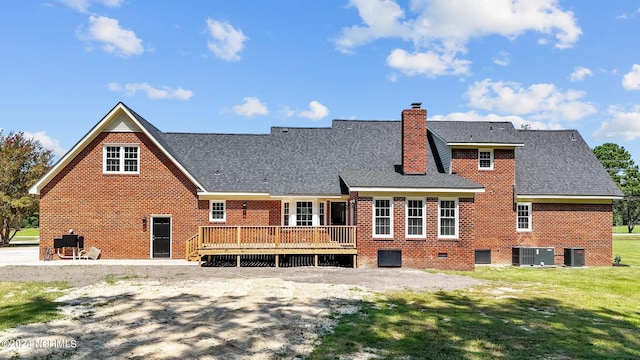 back of house with cooling unit, a wooden deck, and a lawn