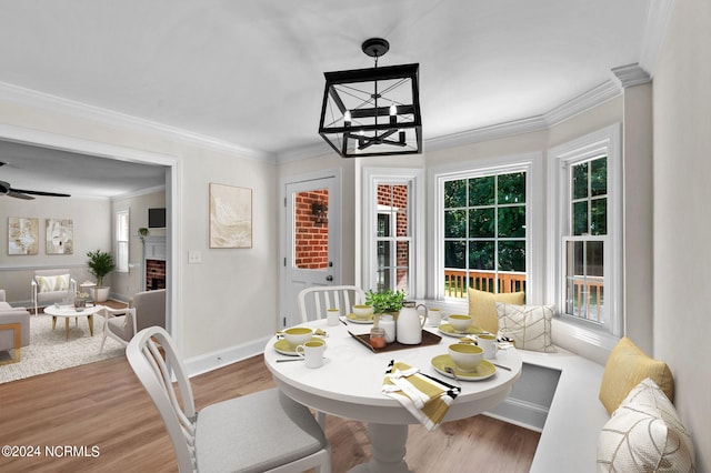 dining area with ceiling fan, ornamental molding, a fireplace, and hardwood / wood-style floors