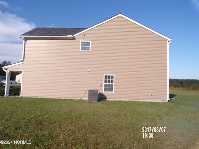 view of property exterior with a yard and central AC unit