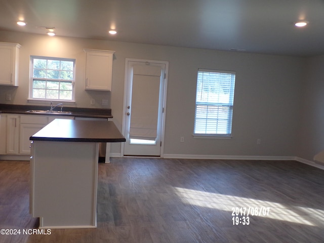 kitchen with a center island, white cabinetry, and dark hardwood / wood-style flooring