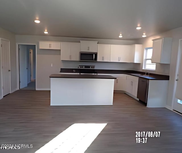 kitchen featuring stainless steel appliances, a center island, hardwood / wood-style floors, and white cabinets