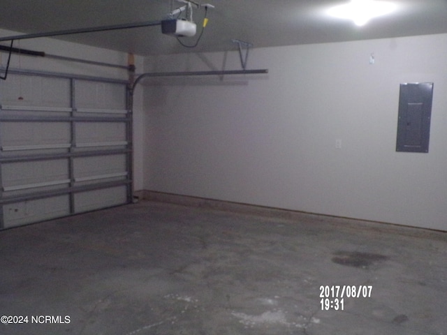 garage with a garage door opener and electric panel