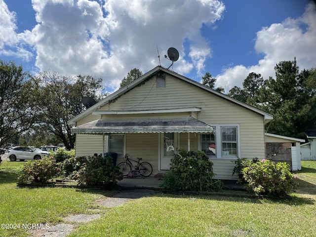 bungalow-style house featuring a porch and a front lawn