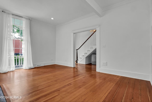 unfurnished room featuring beamed ceiling, crown molding, and hardwood / wood-style flooring